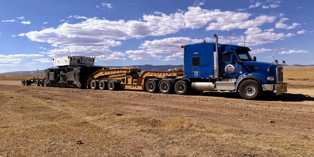 Blue heavy haul semi-truck and heavy haul trailer.