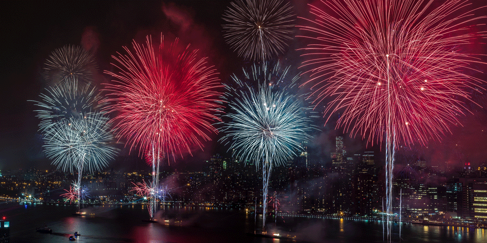 Red, white, and blue fireworks over the Hudson river in NYC.