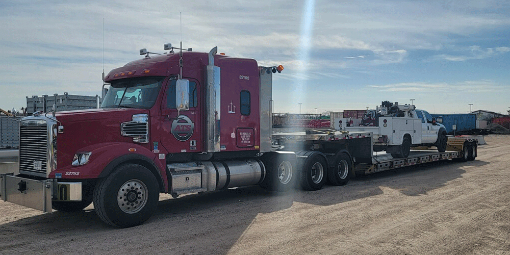 Red ATS semi-truck hauling a step-deck trailer white a small white truck on it.