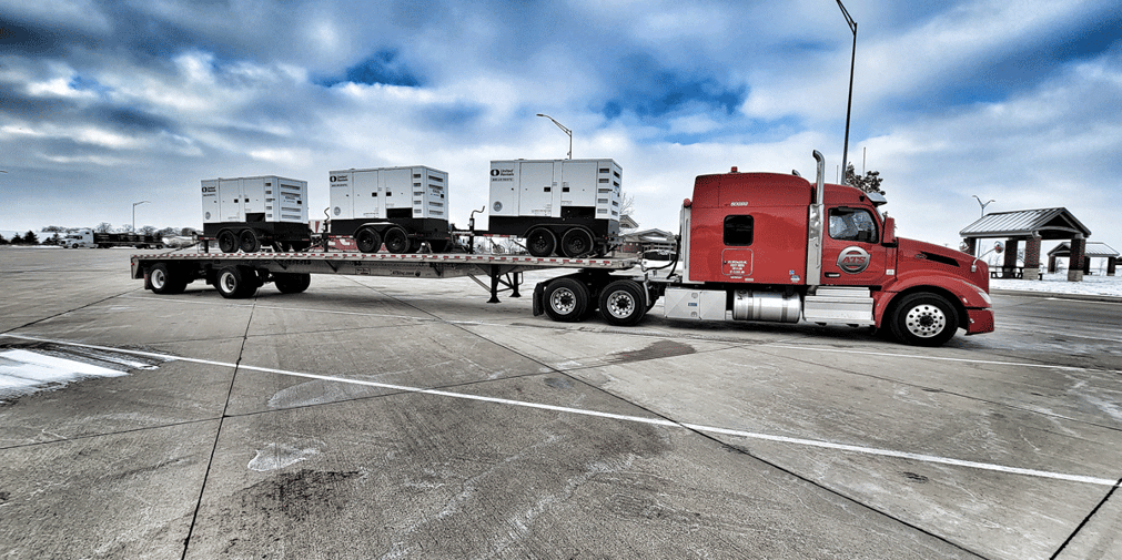A loaded ATS flatbed at a truck stop in winter