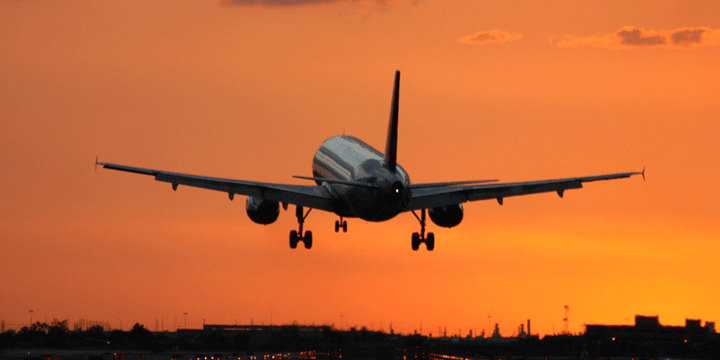 An airplane takes off at sunrise