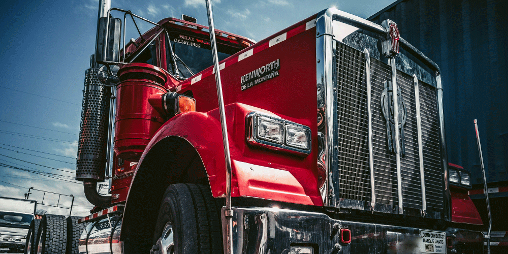 Close-up view of a shiny red Kenworth model.