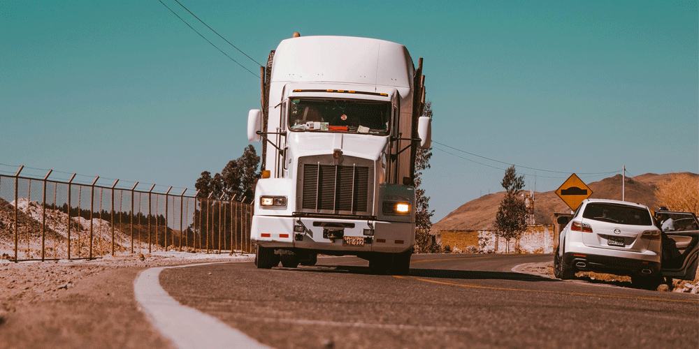 The front view of semi-truck. The photo is taken from the view of the road in front of it.