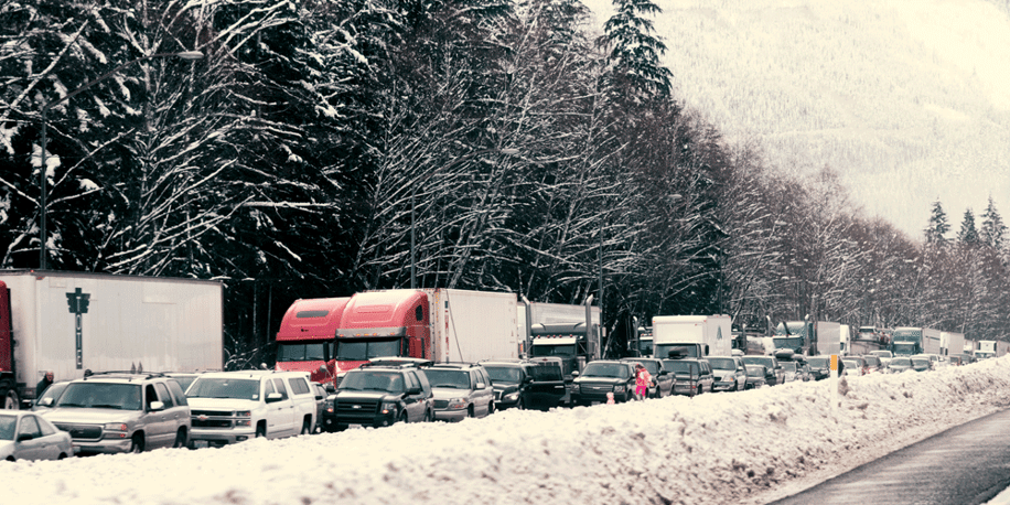 Several semi trucks wait in a winter traffic jam