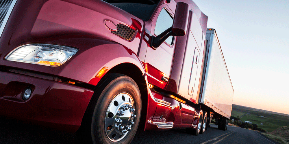 Low left angle of the front of a red semi-truck.