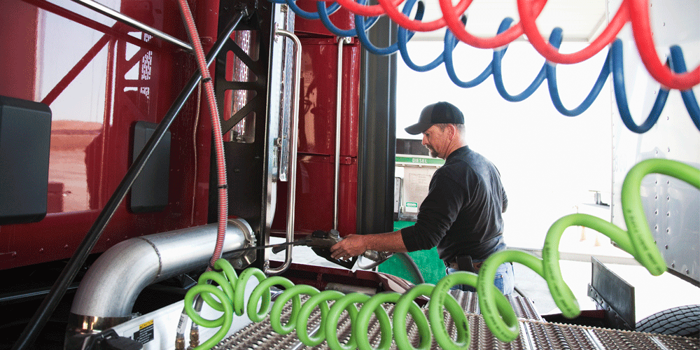 A man filling up his semi-truck tank.