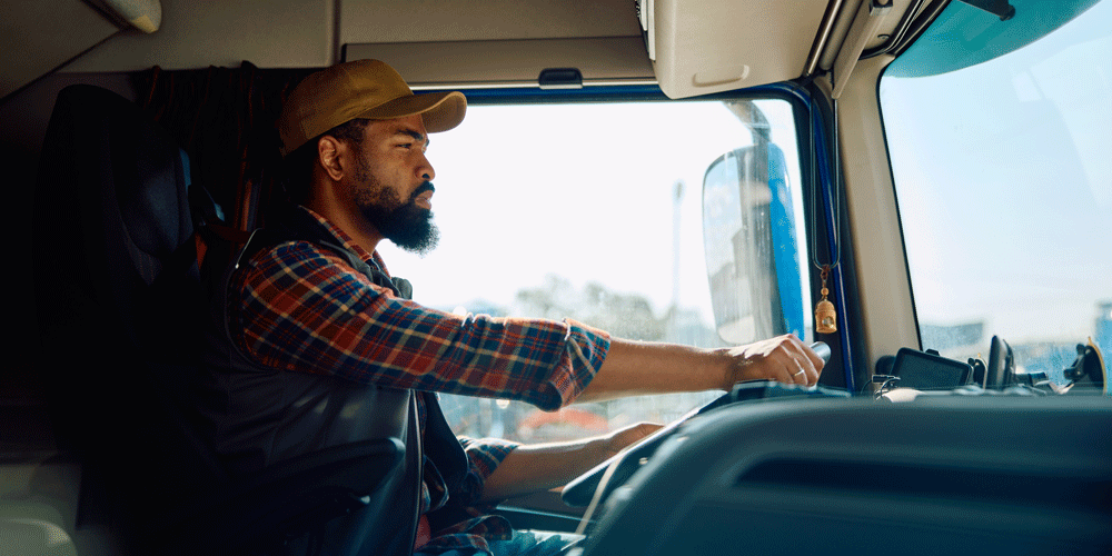 Truck driver focused behind the wheel.