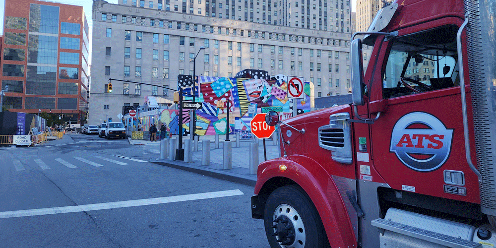 Red ATS semi-truck driving through downtown NYC.