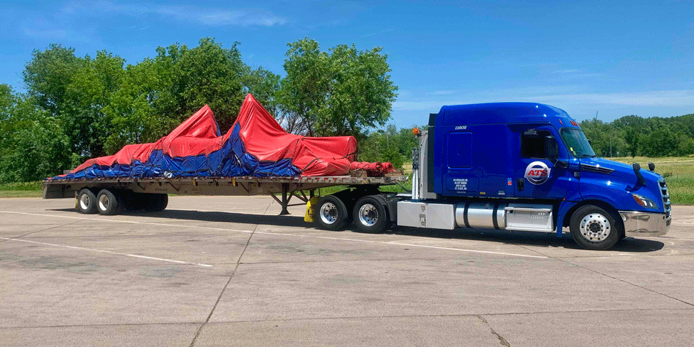 Tarped load on flatbed trailer.