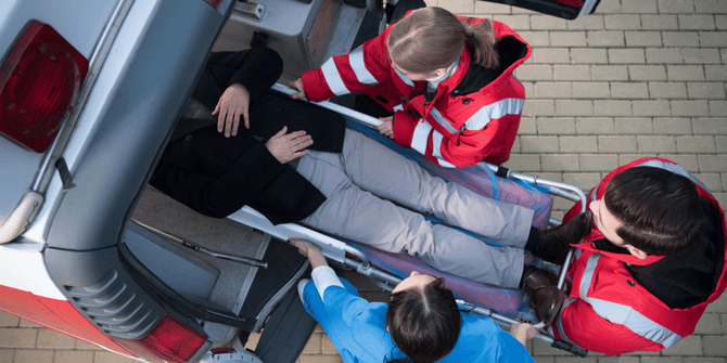 Paramedics loading a person on a stretcher into the back of an ambulance, DOT accidents, Anderson Trucking Service