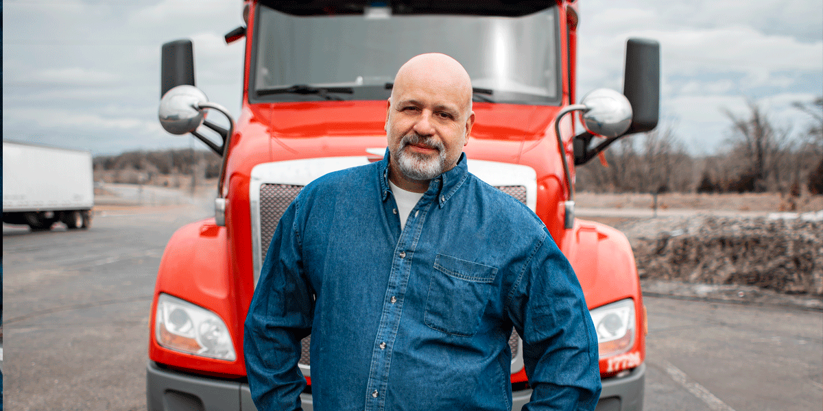 Truck driver standing in front of an ATS semi-truck