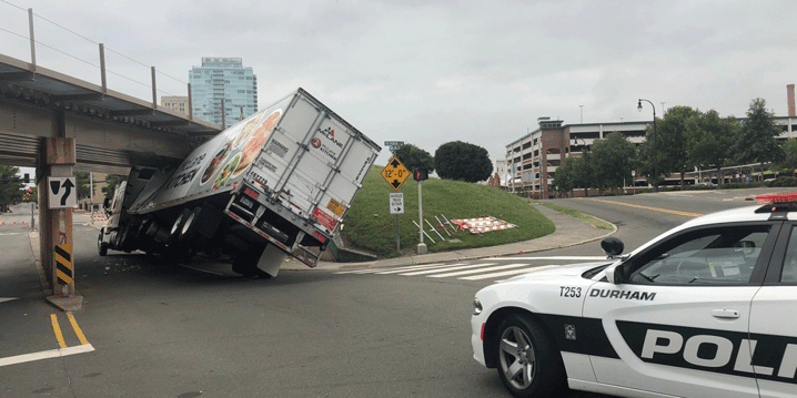 A dry van truck wedged and stuck underneath a bridge as police try and assist; CDL disqualifications, Anderson Trucking Service