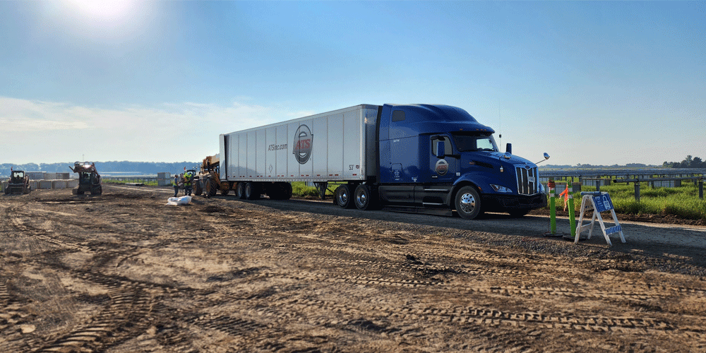 Truck with dry van driving through construction site.