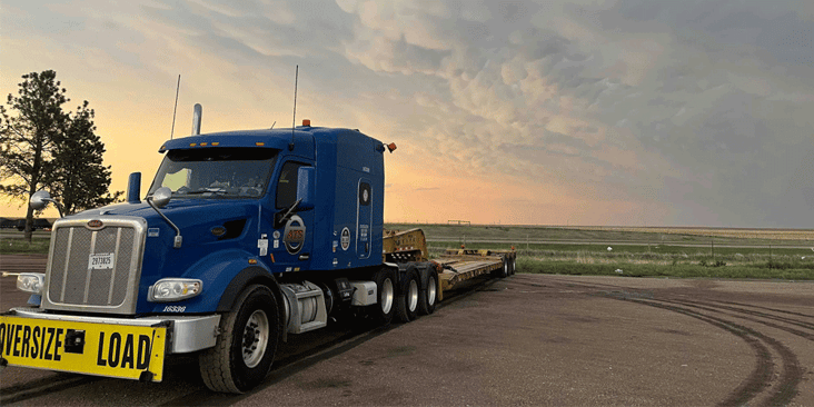 An ATS flatbed truck sits parked in a rural lot