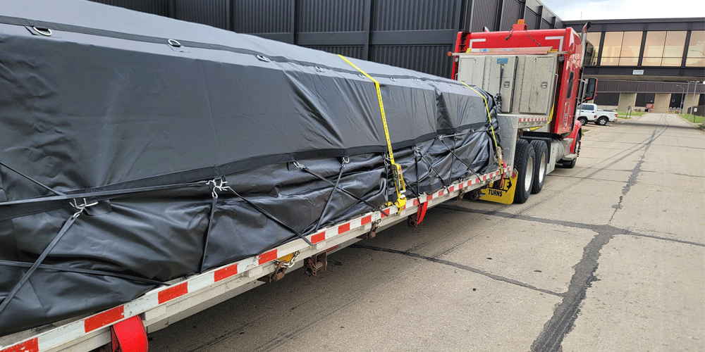 Close view of a tarped load on a flatbed trailer.