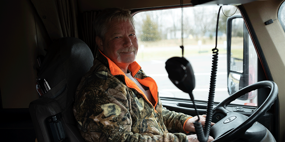 Smiling truck driver sitting in his truck.