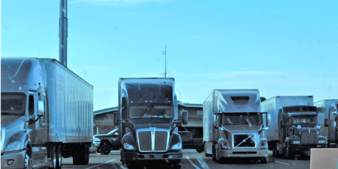 Row of semi-trucks parked in a row; best lease-purchase trucking companies; ATS; Anderson Trucking Service; truck lease