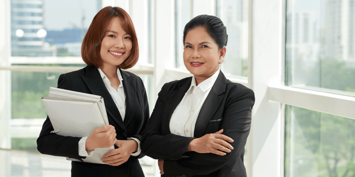 Two female lawyers standing together inside office building
