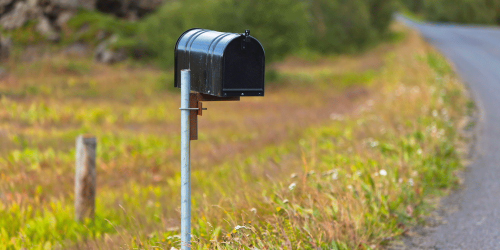 A weathered mailbox on a rural road.