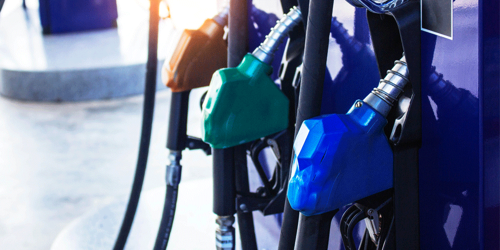 Three fuel nozzles at a fuel pump colored orange, green and blue.