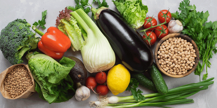 Various fruits, grains, and herbs lay upon a counter