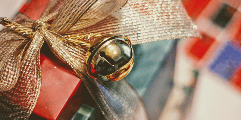 Presents wrapped and decorated in a jingle bell bow