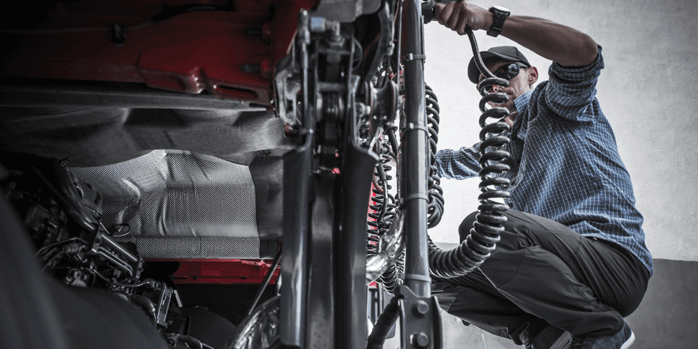 Man attaching cables on his semi-truck.