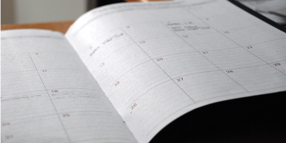White lined planner with a calendar.