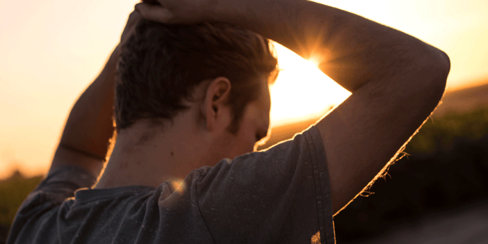 Man at sunset with his hands placed over his head. His back is to the camera, truck driver mental health tips, ATS, Anderson Trucking Service