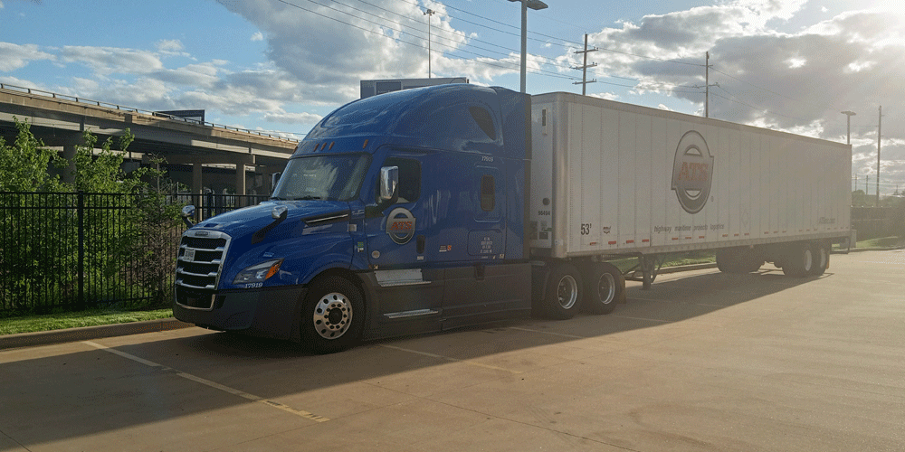 Blue ATS semi-truck and dry van parked in front of an overpass.