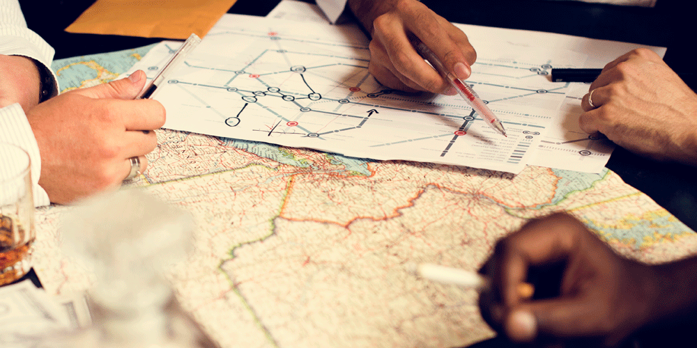 Several people gathered around a map planning a route.