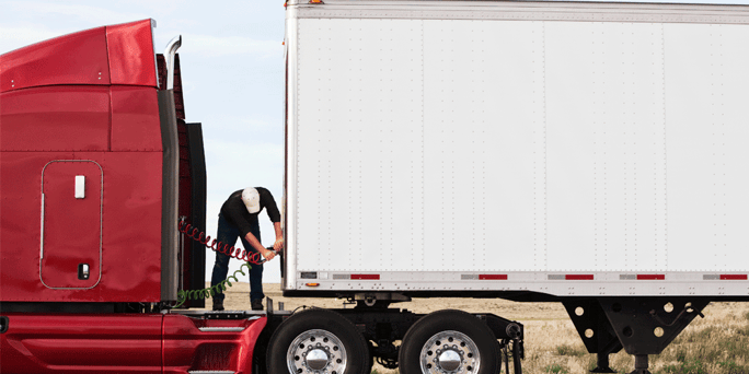 Driver connecting cables on a semi-truck hauling a van trailer; Anderson Trucking Service; ATS; what is the best semi-truck to buy