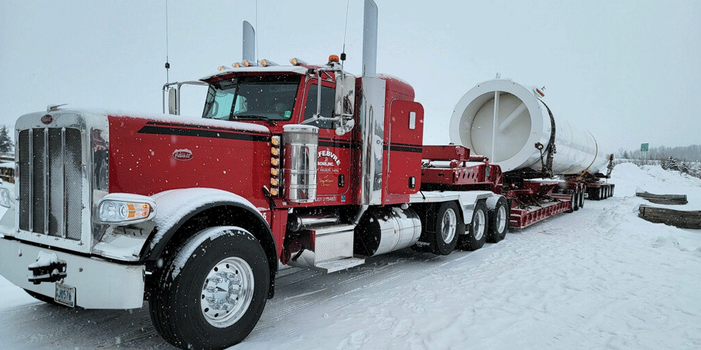 Red Peterbilt truck parked in the snow.
