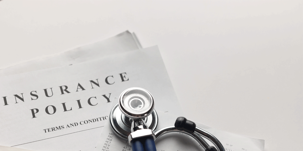 Health insurance policy lying on a white background. A stethoscope lies on top of it.