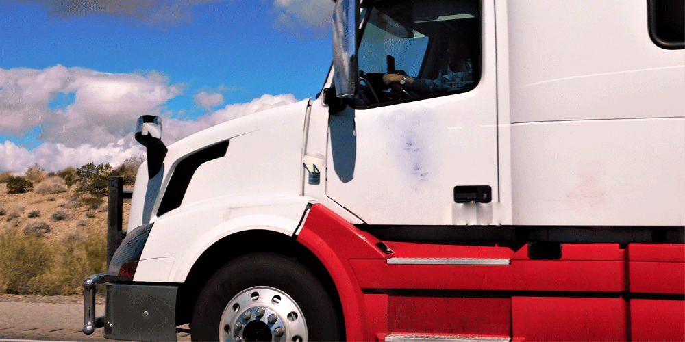 Side front view of a red and white semi-truck.