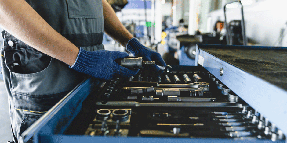 A mechanic selects tools from a toolbox