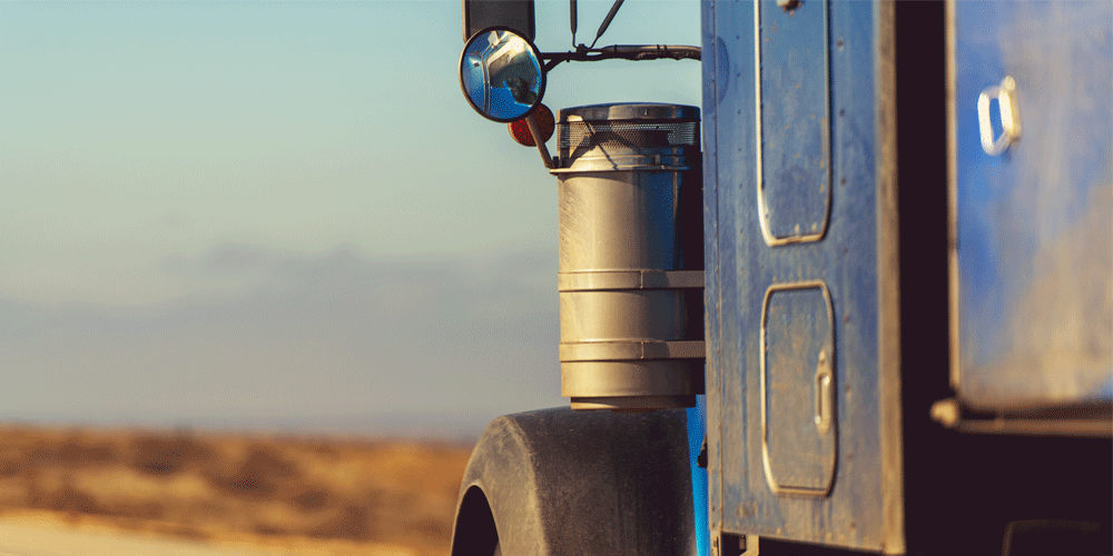 Close view of the side of a dusty blue semi.