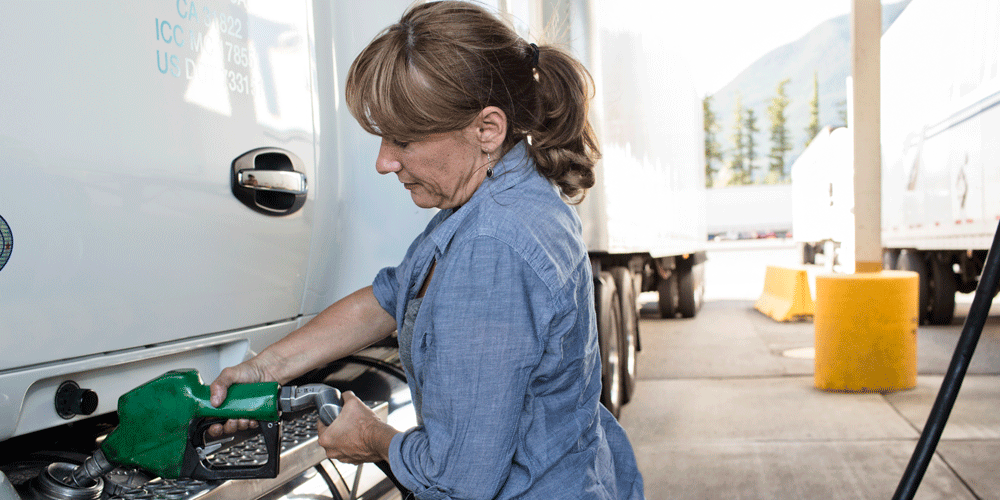 Truck driver fueling her semi-truck.