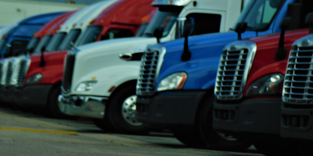 A lineup of red, white, and blue semi-trucks.