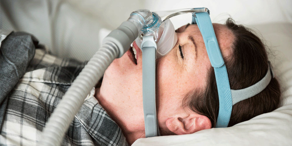 Sleeping woman with CPAP machine.