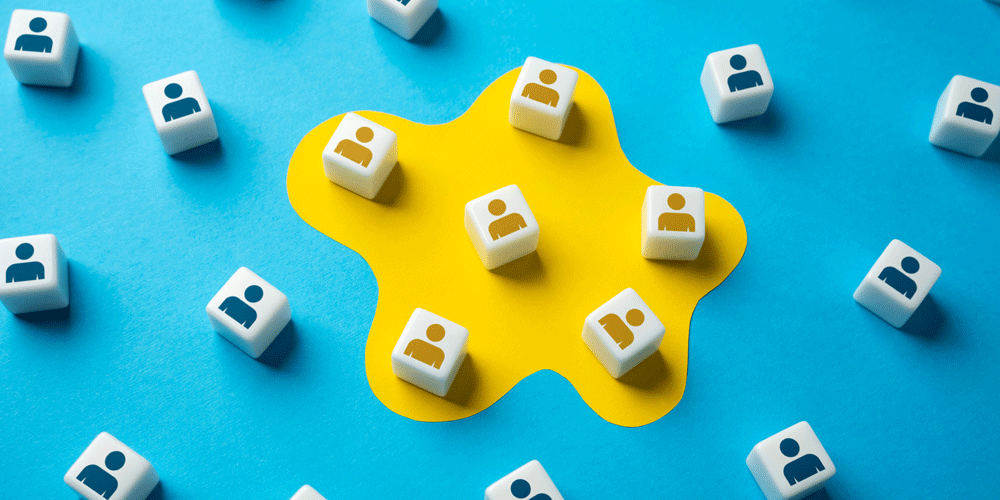 White dice with a human outline on them laying on a blue and yellow background.
