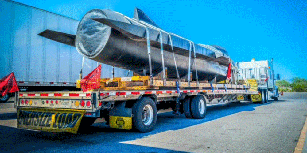 ATS truck hauling an oversized load. The load looks like a rocket or a small aircraft.