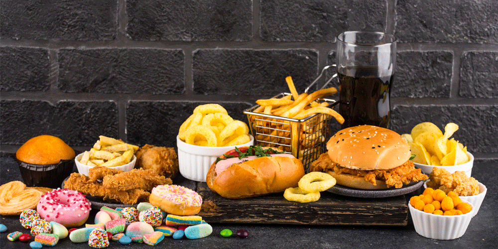 Junk food spread including donuts, chicken fingers, fries, and candy.