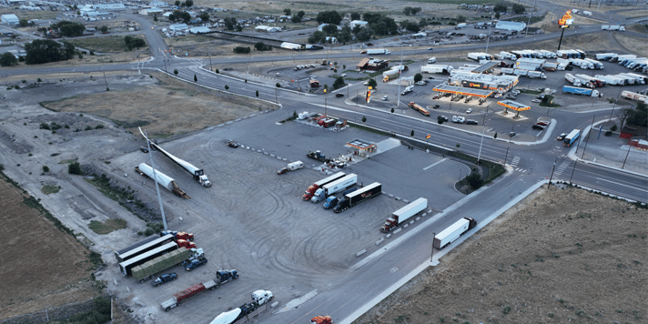 A chain truck stop with two parking lots. One is close to full and the other is almost empty.