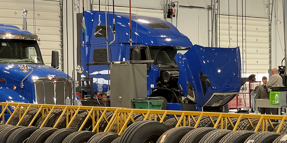 A blue ATS tractor in the shop for maintenance.