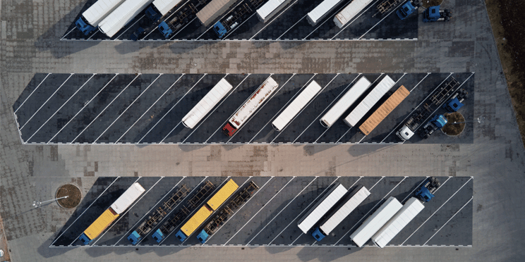 Bird's eye view of a parking lot with semi-trucks parked, switching trucking jobs