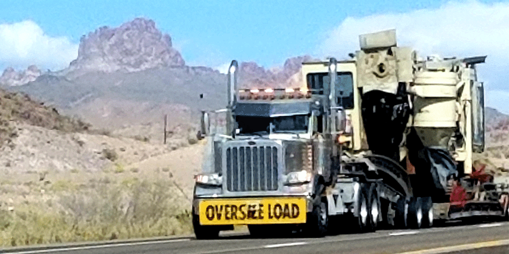 Semi-truck with oversize load banner.