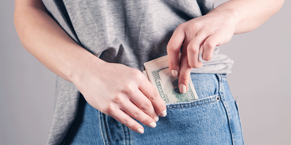 Woman putting cash in her pocket.