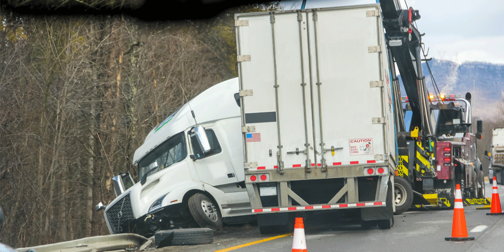 Jackknifed truck and trailer on the side of the road.