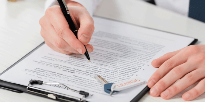 Person looking over a commercial truck lease contract; best lease-purchase trucking companies; ATS; Anderson Trucking Service